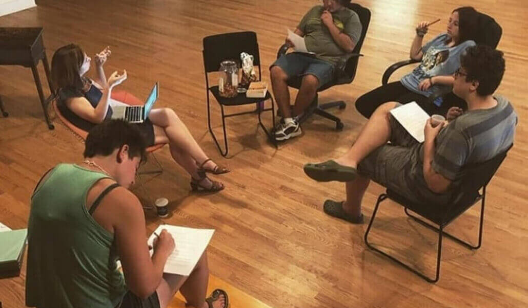 A group of young playwrights sitting in a circle brainstorming