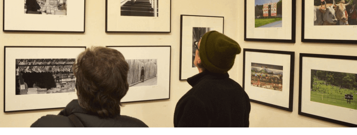 Gallery attendees observing framed black and white photography